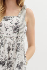 Floral print shoulder tie babydoll dress pullover mini dress featuring stripe pattern border hem. Elasticated smocking at back. Pockets at side.