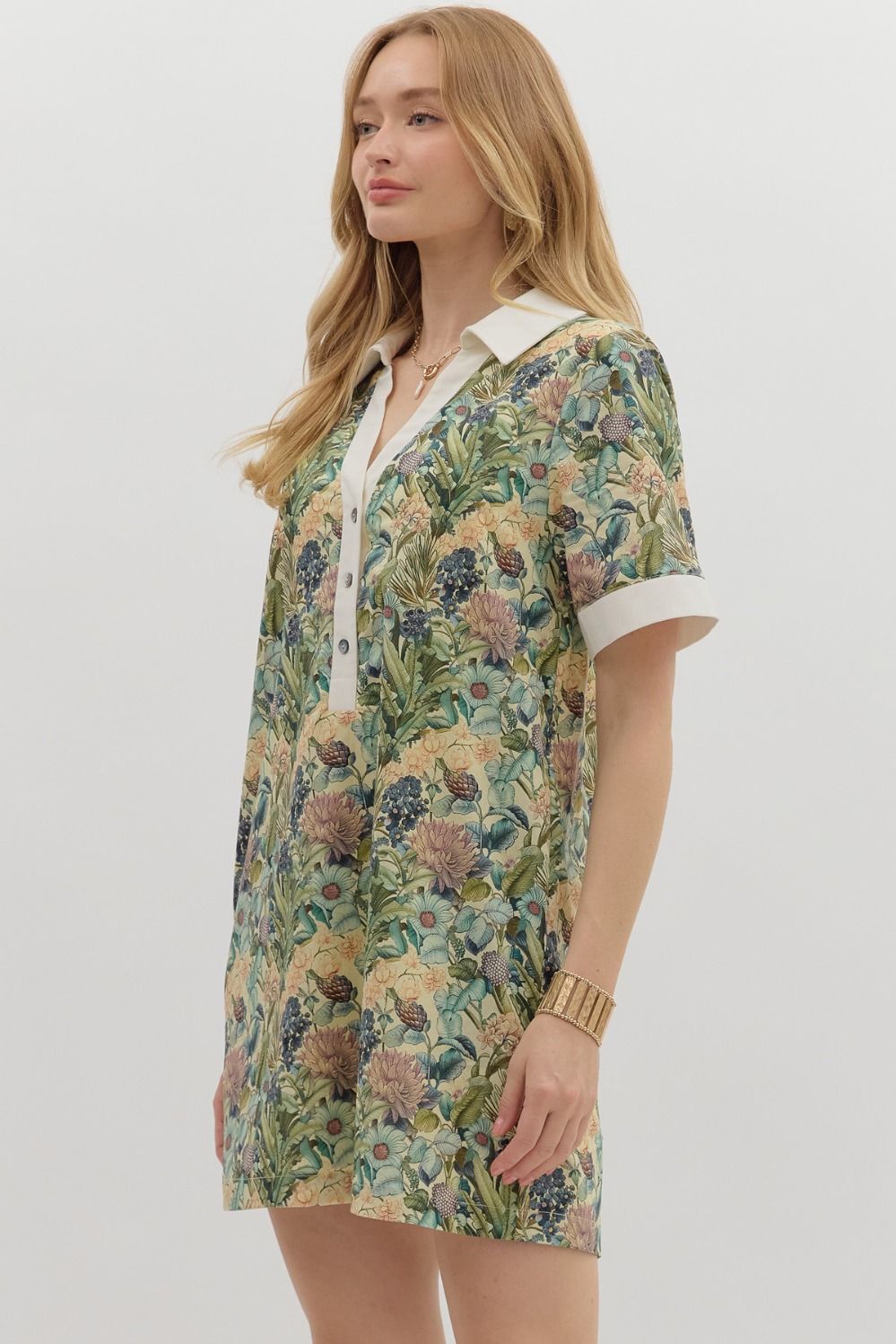 Floral print short sleeve mini dress featuring contrast accent collar button closure and band detail. Pockets at