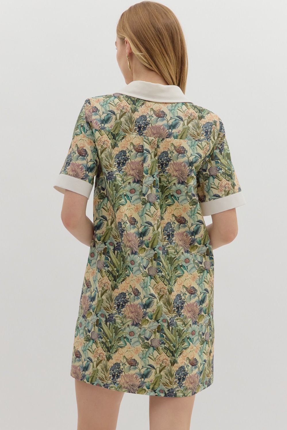 Floral print short sleeve mini dress featuring contrast accent collar button closure and band detail. Pockets at