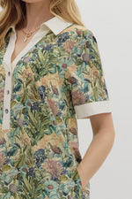 Floral print short sleeve mini dress featuring contrast accent collar button closure and band detail. Pockets at