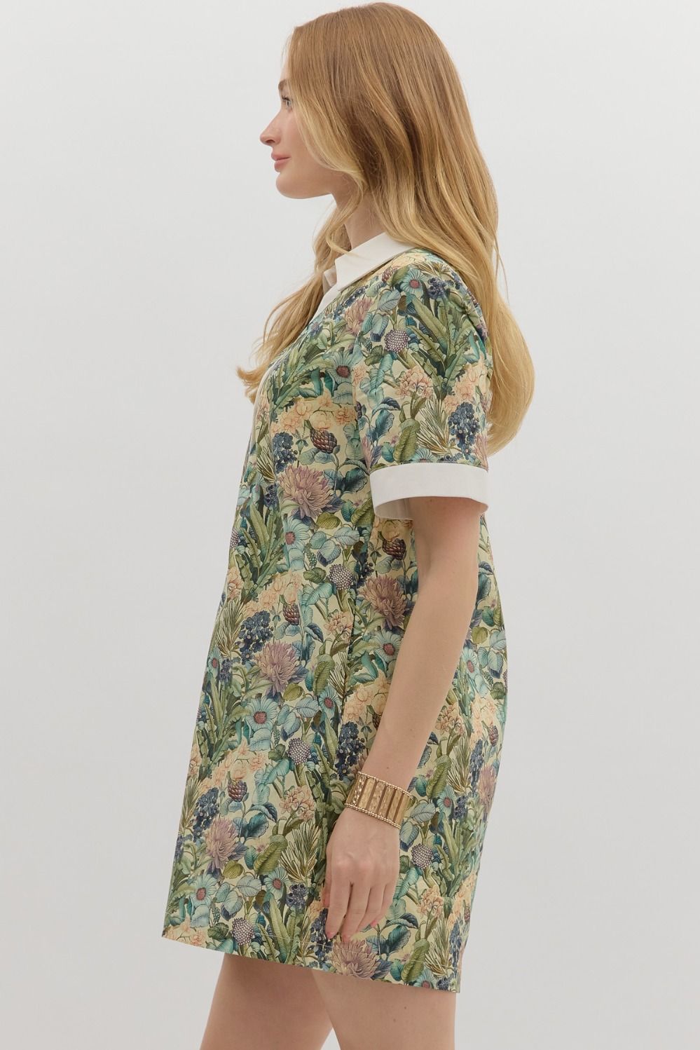 Floral print short sleeve mini dress featuring contrast accent collar button closure and band detail. Pockets at