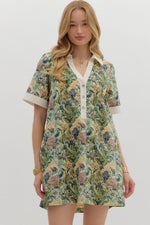 Floral print short sleeve mini dress featuring contrast accent collar button closure and band detail. Pockets at