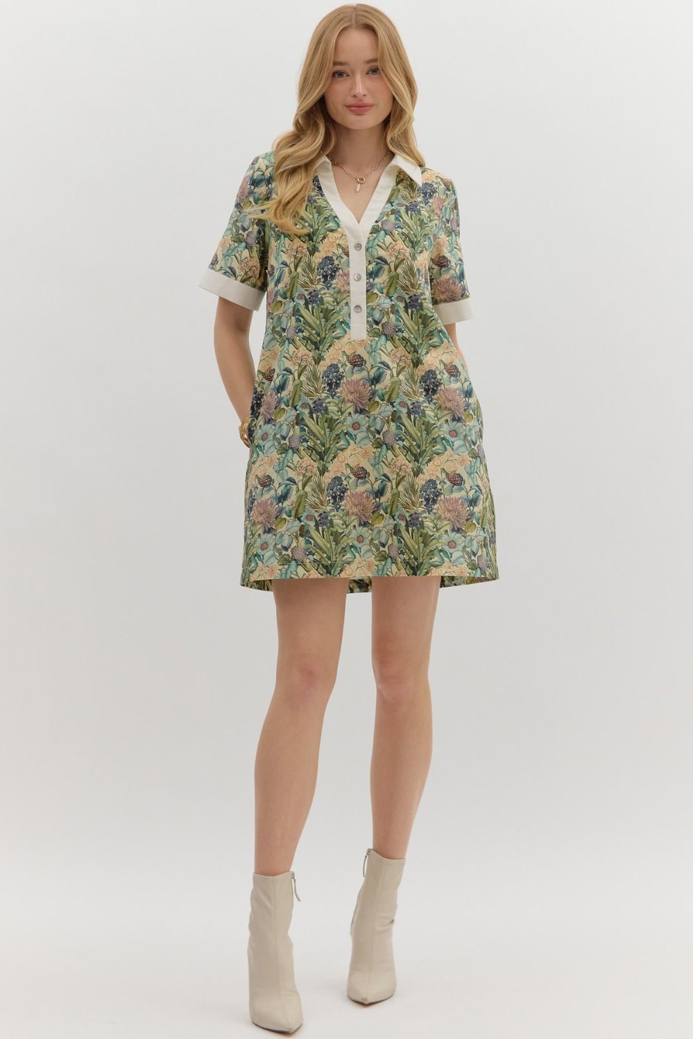 Floral print short sleeve mini dress featuring contrast accent collar button closure and band detail. Pockets at