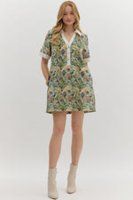 Floral print short sleeve mini dress featuring contrast accent collar button closure and band detail. Pockets at
