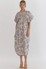 Floral print v-neck bubble sleeve collared midi dress featuring smocking and button detail at front. Slit at sides. Hook and eye closure at front. Elastic at cuff.