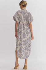 Floral print v-neck bubble sleeve collared midi dress featuring smocking and button detail at front. Slit at sides. Hook and eye closure at front. Elastic at cuff.