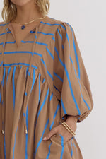 Stripe print babydoll 3/4 sleeve mini dress featuring self tie at front. Elastic at cuff. Pocket at sides.