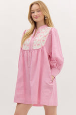 Striped ¾ button closure cuff sleeve pullover mini dress featuring accented floral ribbon pattern yoke. Front neck band tie closure. Pockets at side. Lined.