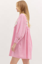 Striped ¾ button closure cuff sleeve pullover mini dress featuring accented floral ribbon pattern yoke. Front neck band tie closure. Pockets at side. Lined.