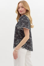Floral print split v-neck pullover top featuring accented scallop pattern binding finish short sleeve and hem.